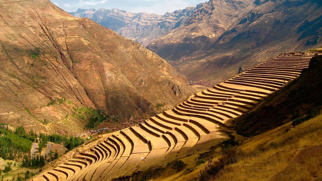 A vibrant, colorful market in South America surrounded by mountains.